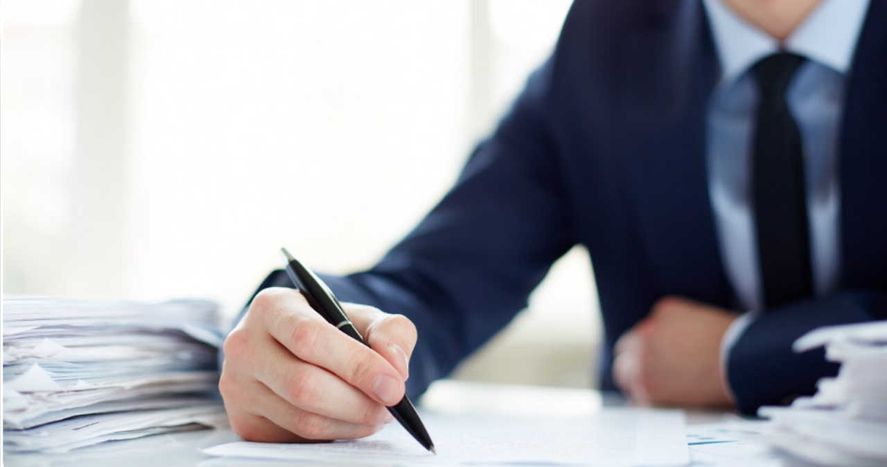 O cerere completată pentru eliberarea unei adeverințe de salariat așezată pe un birou corporativ luminos