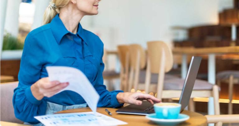 O cerere pentru recuperarea orelor suplimentare printată așezată lângă o agendă și o cafea pe un birou modern