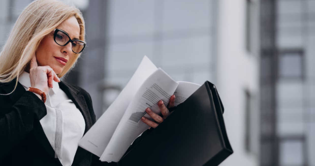 O invitație corporate elegantă printată așezată lângă o agendă și o ceașcă de cafea pe un birou