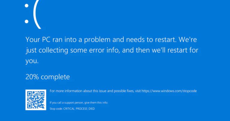 un monitor de calculator pe care este afisata eroarea de ecran albastru din windows alaturi de un laptop