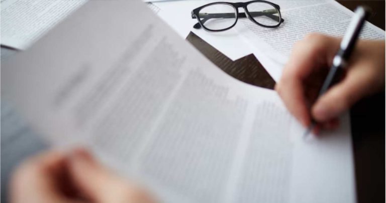 un document printat cu o cerere de demisie completata pe un birou alaturi de un pix