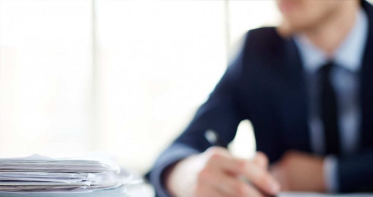 un formular de chitanta de mana completat cu pixul asezat pe un birou alaturi de niste bancnote