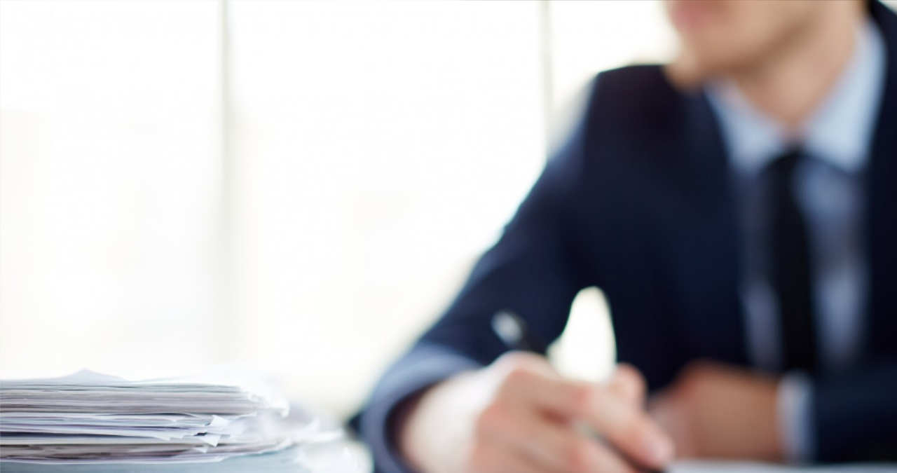 un formular de chitanta de mana completat cu pixul asezat pe un birou alaturi de niste bancnote