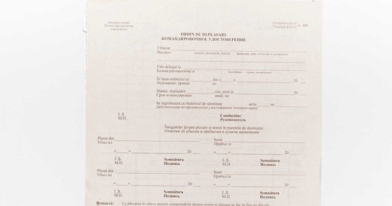 Un formular de ordin de deplasare completat, așezat pe un birou corporativ lângă o ștampilă