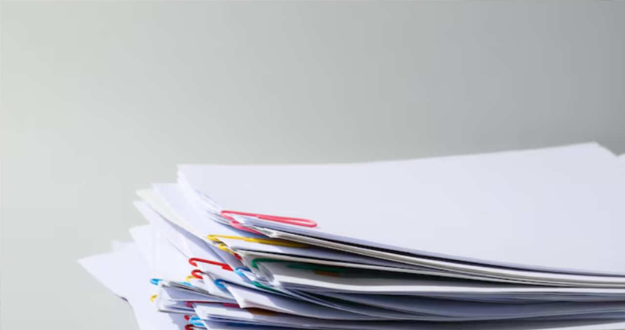 un birou modern de corporatie cu un laptop si un document printat tip proces verbal alaturi