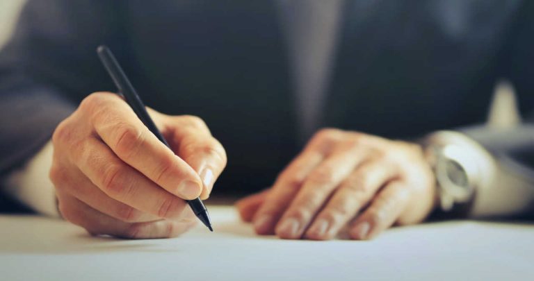 Un referat de necesitate pentru achiziții corporative printat și semnat, așezat pe un birou